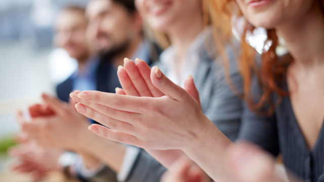 Photo of business people hands applauding at conference