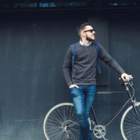Lifestyle and transportation A young stylish hipster posing next to his bicycle.